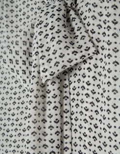 Blusa con lazada estampado geométrico blanco y negro
