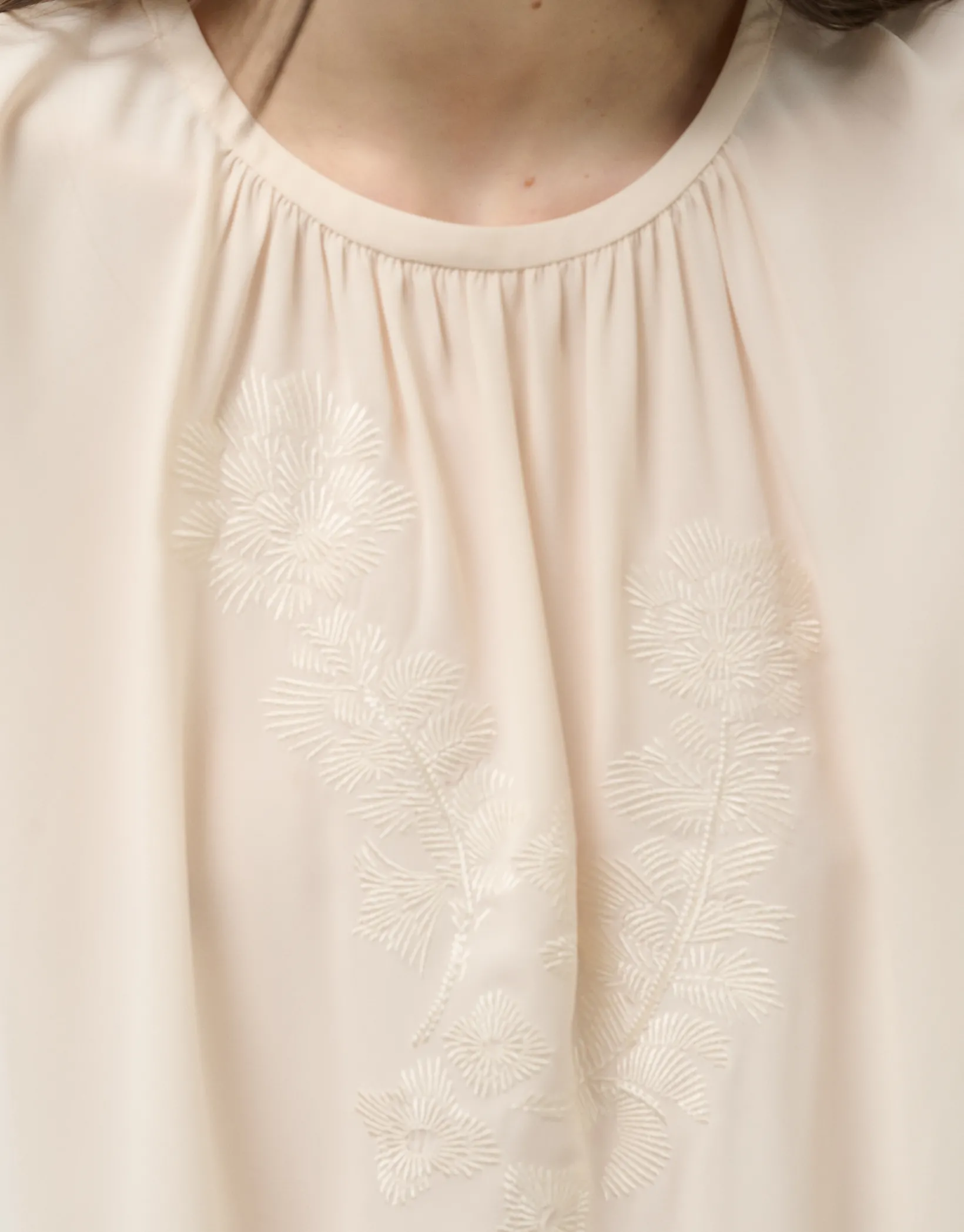 Top tejido fluido beige con bordado floral